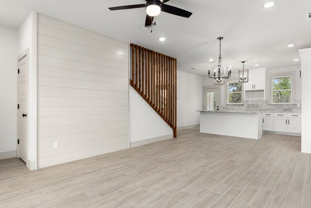 5703 Barkridge Dr, Granbury, TX 76048 - unfurnished living room with light wood-style flooring, ceiling fan with notable chandelier, visible vents, and recessed lighting