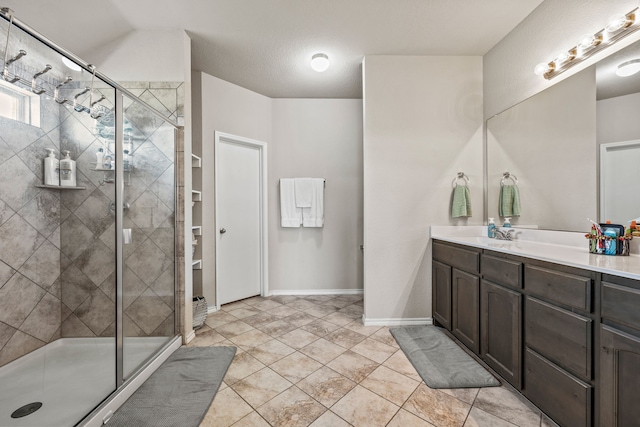 full bath featuring a shower stall, vanity, baseboards, and tile patterned flooring