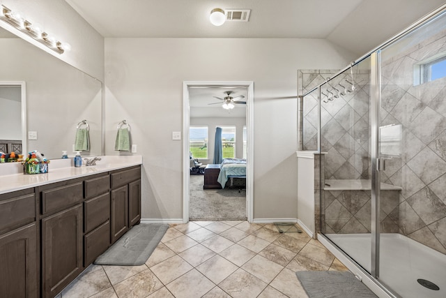 ensuite bathroom with a shower stall, a ceiling fan, ensuite bath, and vanity