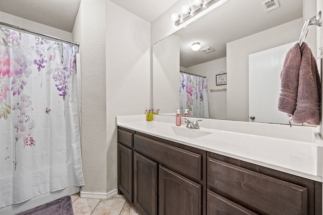 bathroom with tile patterned floors, vanity, visible vents, and baseboards