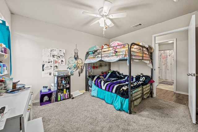 bedroom featuring a ceiling fan, visible vents, and carpet floors