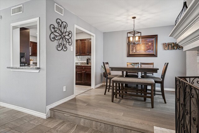 12550 Burninglog Ln, Dallas, TX 75243 - dining space featuring baseboards, visible vents, and light wood-type flooring