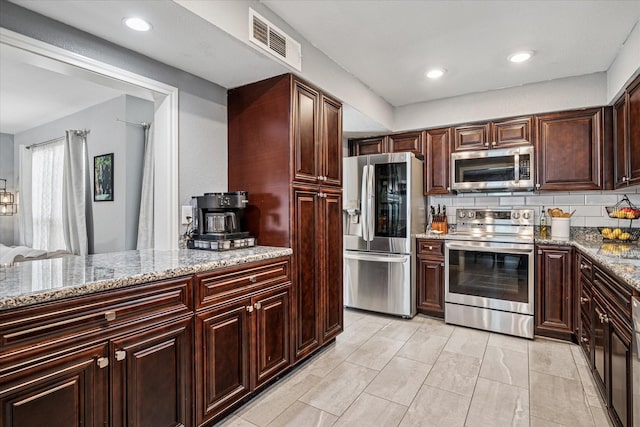 12550 Burninglog Ln, Dallas, TX 75243 - kitchen with appliances with stainless steel finishes, light stone counters, recessed lighting, decorative backsplash, and visible vents