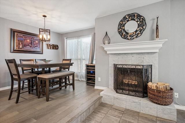 12550 Burninglog Ln, Dallas, TX 75243 - dining space featuring baseboards, wood finished floors, a fireplace, and an inviting chandelier