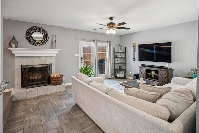 12550 Burninglog Ln, Dallas, TX 75243 - living area with baseboards, ceiling fan, a fireplace with raised hearth, and stone finish flooring
