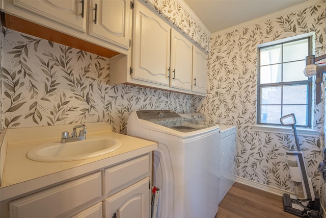 laundry room with a sink, wallpapered walls, and cabinet space