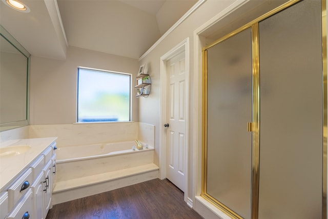 bathroom featuring a stall shower, wood finished floors, vanity, and a garden tub