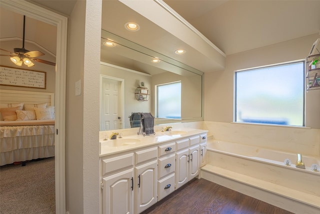 full bathroom featuring ceiling fan, a garden tub, double vanity, and a sink