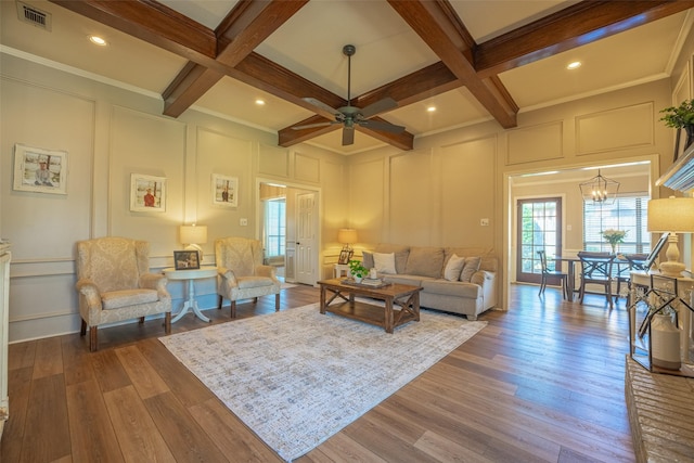 living room with a decorative wall, visible vents, beam ceiling, and coffered ceiling