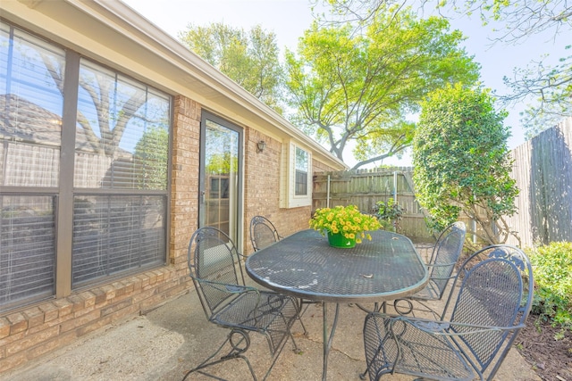 view of patio with outdoor dining area and fence
