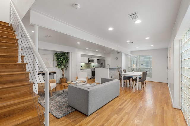 4122 Travis St Unit 7, Dallas, TX 75204 - living room featuring stairs, recessed lighting, light wood-style flooring, and baseboards