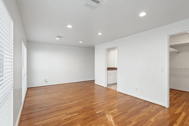 4122 Travis St Unit 7, Dallas, TX 75204 - unfurnished bedroom with a walk in closet, light wood-style flooring, recessed lighting, ensuite bath, and a closet