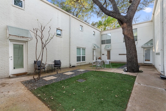 4122 Travis St Unit 7, Dallas, TX 75204 - rear view of property featuring a patio area, a lawn, and brick siding
