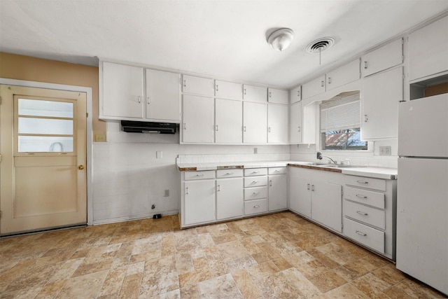 302 S S Ave G, Clifton, TX 76634 - kitchen featuring visible vents, freestanding refrigerator, backsplash, white cabinetry, and stone finish flooring
