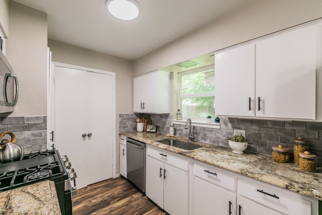 1807 Lachelle Ln, Arlington, TX 76010 - kitchen featuring appliances with stainless steel finishes, a sink, backsplash, dark wood-style floors, and white cabinetry