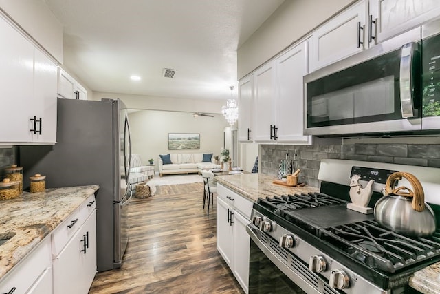 1807 Lachelle Ln, Arlington, TX 76010 - kitchen featuring appliances with stainless steel finishes, white cabinets, backsplash, open floor plan, and recessed lighting
