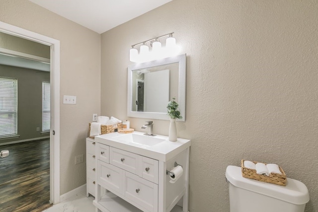1807 Lachelle Ln, Arlington, TX 76010 - bathroom with vanity, toilet, wood finished floors, and a textured wall
