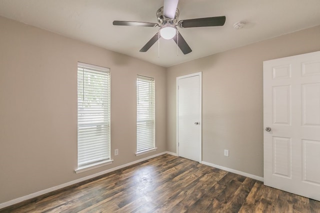 1807 Lachelle Ln, Arlington, TX 76010 - unfurnished bedroom featuring baseboards, dark wood-style flooring, and a ceiling fan