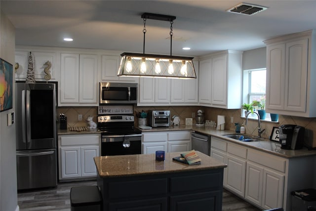 12824 Kingsgate Dr, Rhome, TX 76078 - kitchen with white cabinetry, visible vents, a center island, appliances with stainless steel finishes, and a sink