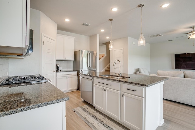 628 Bronze Forest Dr, Fort Worth, TX 76131 - kitchen with a sink, appliances with stainless steel finishes, open floor plan, dark stone countertops, and light wood-type flooring