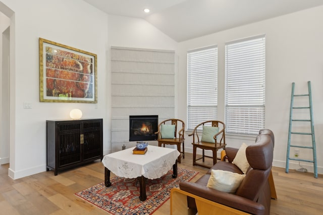 808 Bluestem Dr, Aubrey, TX 76227 - sitting room with a glass covered fireplace, light wood finished floors, lofted ceiling, baseboards, and healthy amount of natural light