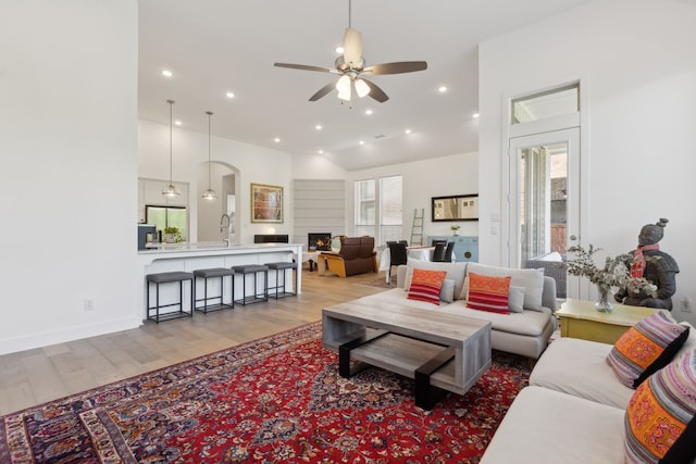 808 Bluestem Dr, Aubrey, TX 76227 - living room featuring light wood-style flooring, a warm lit fireplace, a ceiling fan, and recessed lighting