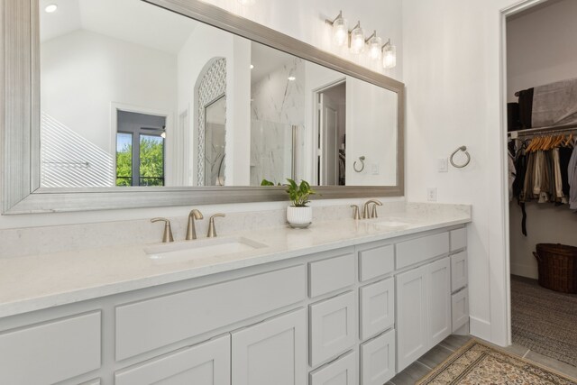 808 Bluestem Dr, Aubrey, TX 76227 - bathroom featuring double vanity, a marble finish shower, lofted ceiling, a spacious closet, and recessed lighting