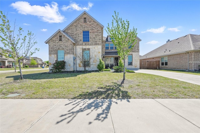 view of front of property featuring fence, concrete driveway, a front yard, and stone siding