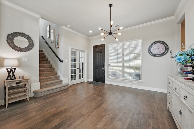 entryway featuring an inviting chandelier, ornamental molding, baseboards, stairway, and dark wood-type flooring