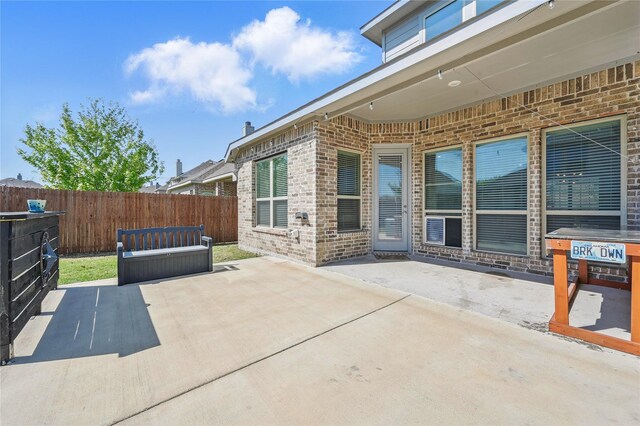 view of patio with a storage unit, an outdoor structure, and a fenced backyard