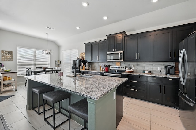 kitchen featuring light tile patterned floors, tasteful backsplash, a sink, visible vents, and stainless steel appliances