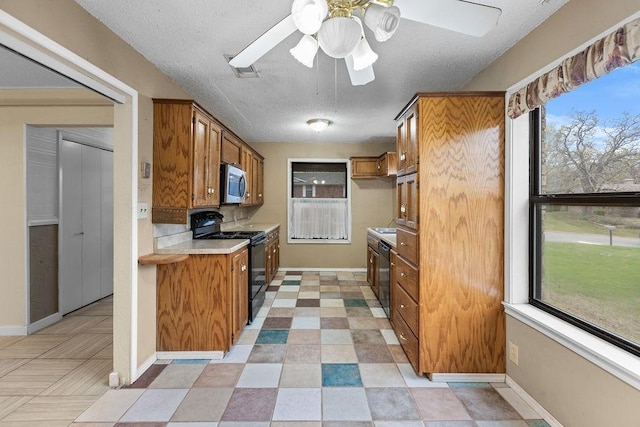 3014 Jennifer Ave, Denison, TX 75020 - kitchen featuring a ceiling fan, black appliances, a healthy amount of sunlight, light countertops, and brown cabinets