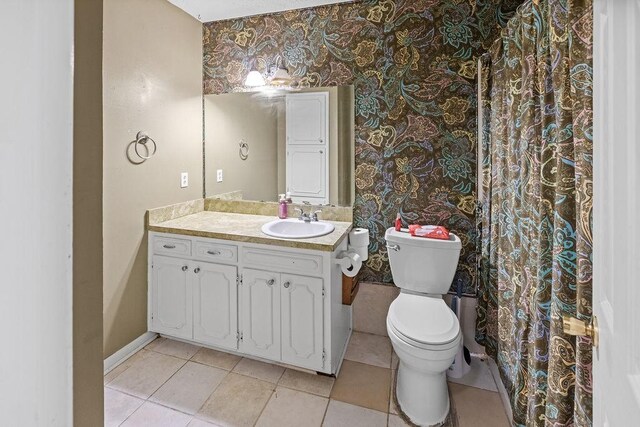 3014 Jennifer Ave, Denison, TX 75020 - bathroom with vanity, toilet, tile patterned floors, wallpapered walls, and baseboards