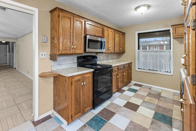 3014 Jennifer Ave, Denison, TX 75020 - kitchen featuring stainless steel microwave, tasteful backsplash, black / electric stove, light countertops, and brown cabinetry