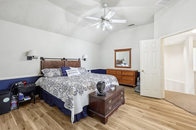 bedroom with visible vents, light wood-type flooring, and vaulted ceiling
