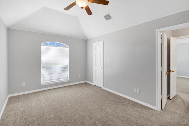 carpeted spare room featuring baseboards, lofted ceiling, a ceiling fan, and visible vents