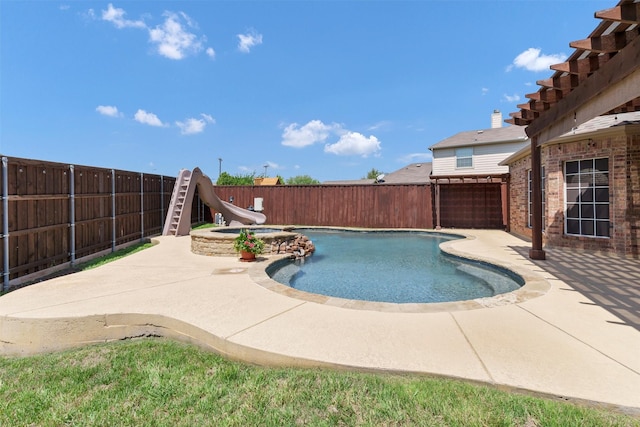 view of swimming pool with a patio, a pool with connected hot tub, a fenced backyard, and a water slide