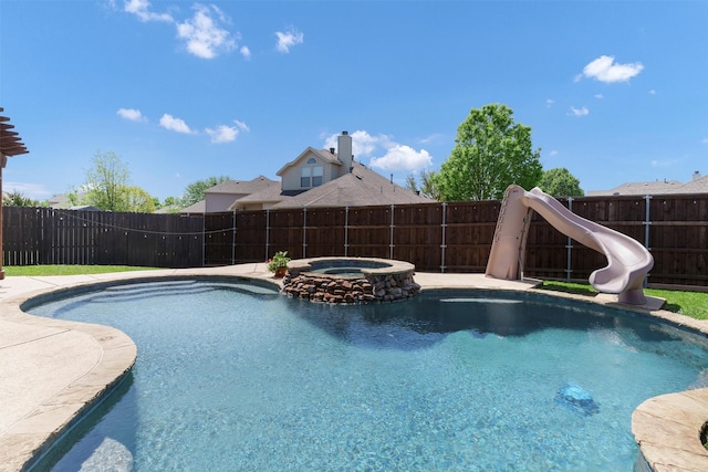 view of pool with a fenced backyard, a pool with connected hot tub, and a water slide
