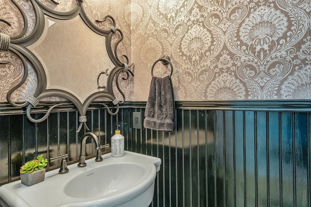 bathroom featuring a wainscoted wall and a sink