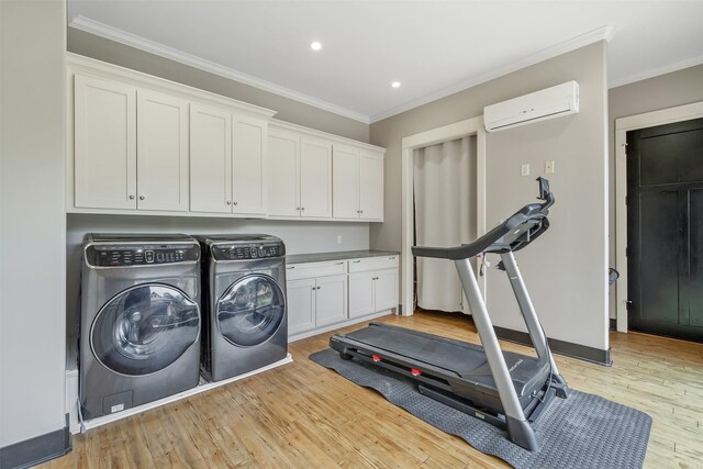 interior space featuring washer and clothes dryer, cabinet space, a wall unit AC, and crown molding