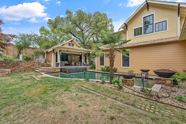 rear view of house with a patio area, a lawn, an outdoor pool, and fence