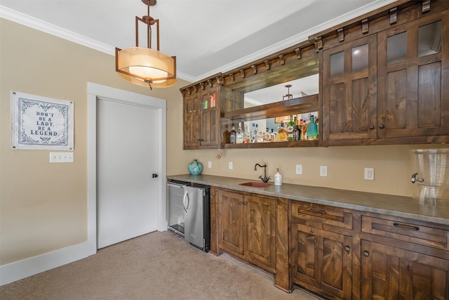 kitchen with a sink, dark countertops, light colored carpet, crown molding, and refrigerator