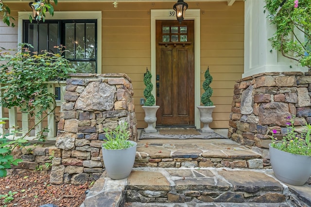 property entrance featuring a porch and stone siding