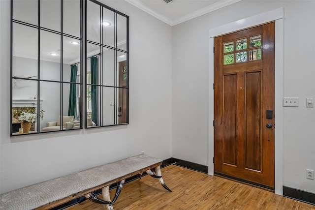 foyer entrance with wood finished floors, baseboards, and ornamental molding