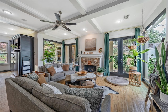 living room with beamed ceiling, visible vents, ornamental molding, and a healthy amount of sunlight