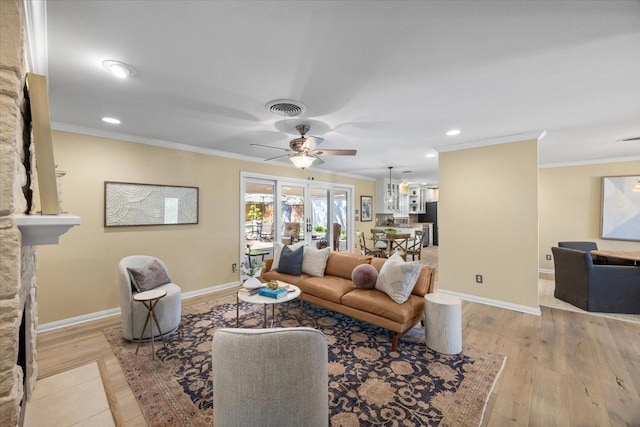 living room with crown molding, light wood-type flooring, a ceiling fan, baseboards, and recessed lighting