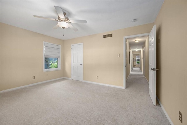 unfurnished bedroom featuring light carpet, baseboards, and ceiling fan
