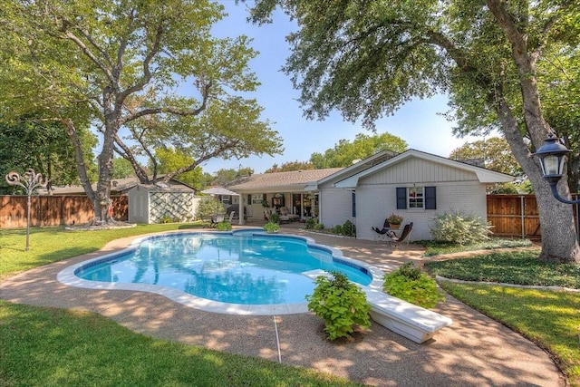 view of swimming pool featuring an outdoor structure, a shed, and a patio area