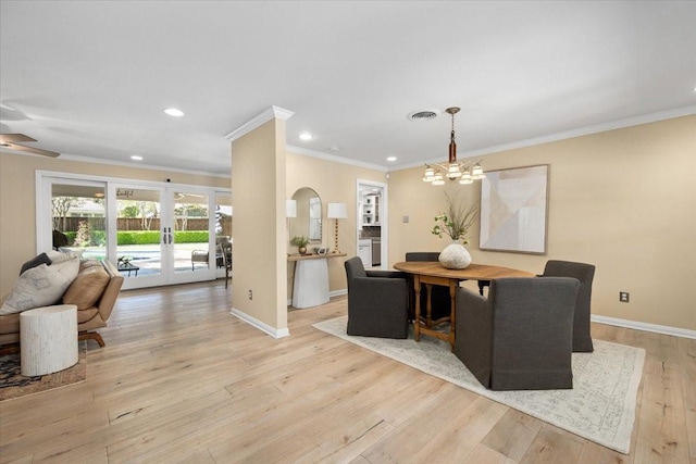 dining room featuring crown molding, a chandelier, light wood-style floors, baseboards, and french doors