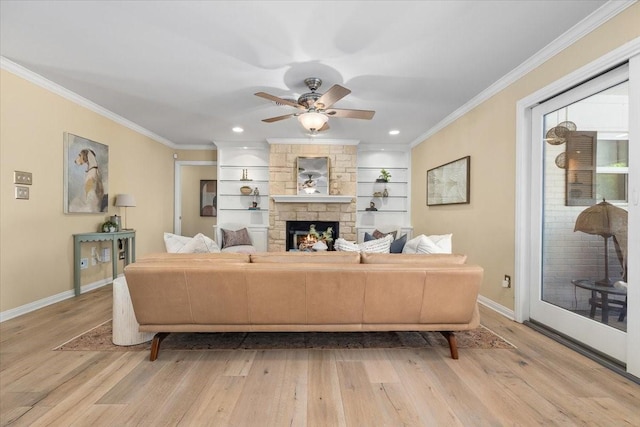 living area featuring baseboards, light wood-style floors, crown molding, a fireplace, and ceiling fan